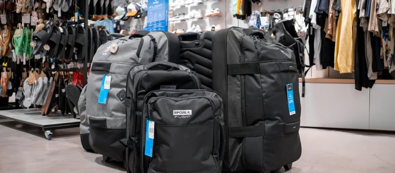 Mochilas y equipaje de estilo surf Rip Curl expuestas en tienda de moda surf en Lanzarote.