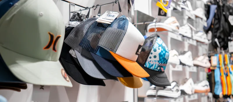 Gorras de estilo surf con diseños variados expuestas en tienda de moda surf en Lanzarote.