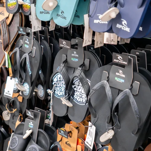 Sandalias y chanclas Rip Curl exhibidas en tienda de moda surf en Lanzarote.