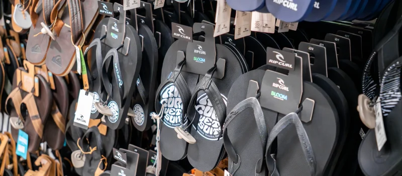 Sandalias y chanclas Rip Curl exhibidas en tienda de moda surf en Lanzarote.
