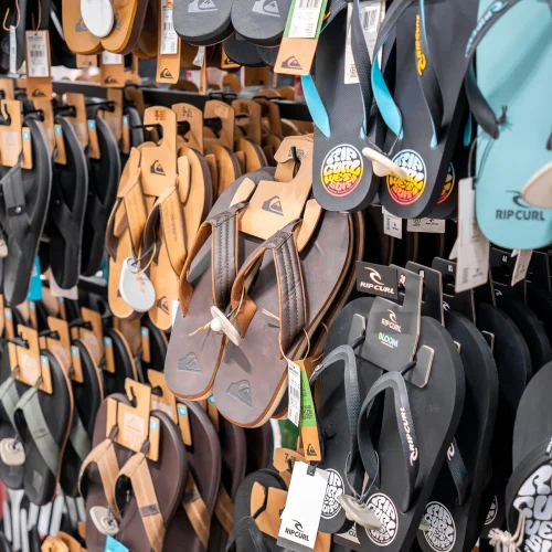 Sandalias y chanclas Rip Curl exhibidas en tienda de moda surf en Lanzarote.