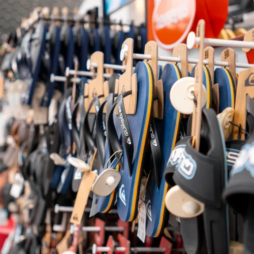 Sandalias y chanclas Rip Curl exhibidas en tienda de moda surf en Lanzarote.
