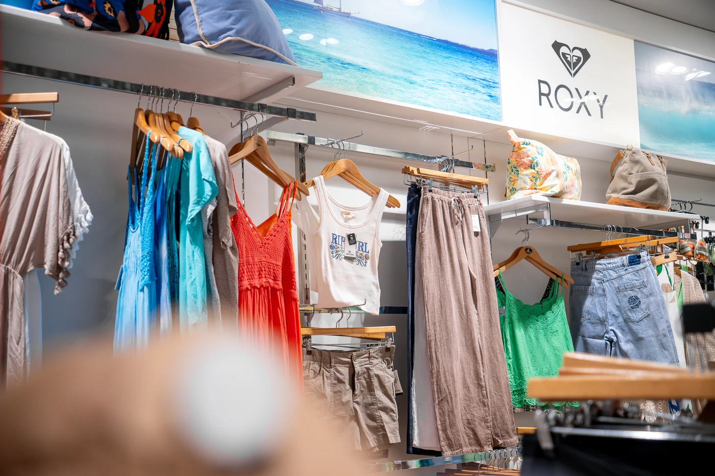 Tienda de ropa de surf con nueva colección en Lanzarote, mostrando camisetas, mochilas y accesorios de moda surf.